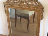 a mirror sitting on the floor in front of a chair