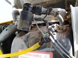 a close up of a car ' s engine with a yellow hose attached to it