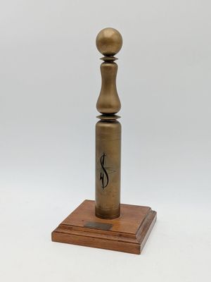 an old brass pepper mill on a wooden base with a white background