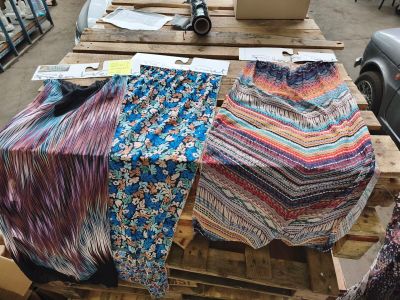many pieces of fabric on a pallet in a warehouse