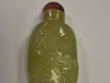 a green glass bottle with a picture of a woman on it