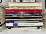 many books stacked on top of each other on a shelf