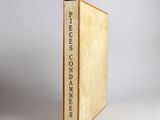 an old book sitting on top of a white table next to a gray wall