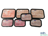 several different types of food are in a black container on a white surface