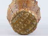 bronze sculpture of a baseball on a white surface with a white background