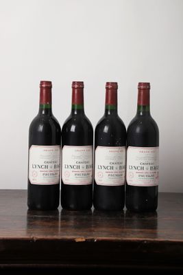 cinq bouteilles de vin sont alignées sur une table en bois