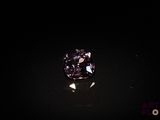 a close up of a purple diamond on a black surface