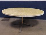 une table au plateau en marbre posée sur un sol en béton