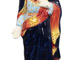 La statue de Jésus porte une couronne et tient une croix.