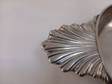 une assiette en argent posée sur une table, avec une cuillère dessus