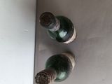 two empty wine bottles sitting on top of a refrigerator