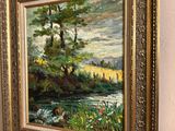 framed oil painting of a river scene with trees and flowers