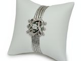 a close up of a white pillow with a ring on top of it