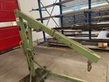 a green crane that is sitting in a warehouse