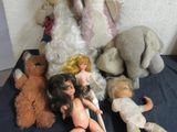 a lot of stuffed animals and dolls on a bed