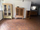 a room with a brick floor and a cabinet in it