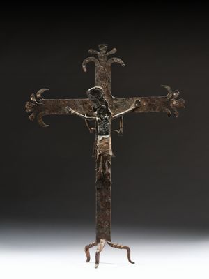 un gros plan d'une croix en métal sur laquelle se trouve une personne