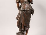 an antique bronze statue of a woman with a dog