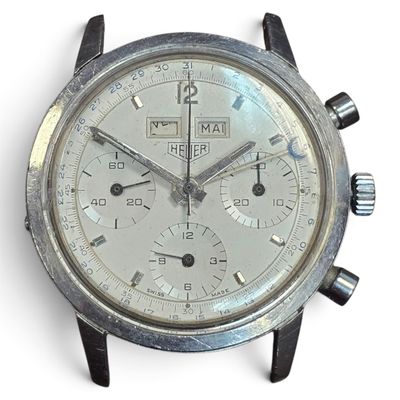 a close up of a silver watch on a white surface