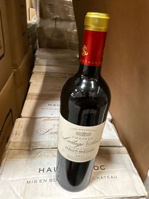 une bouteille de vin posée sur une pile de cartons