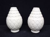 two white vases that are sitting on a table