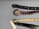 trois types différents de ceintures en cuir, chacune munie d'une étiquette