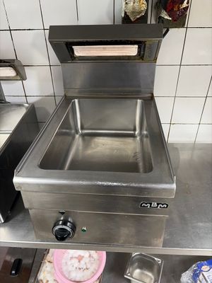 un évier dans une cuisine où il y a beaucoup de nourriture sur le plan de travail