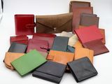 de nombreux portefeuilles en cuir de différentes couleurs posés sur une surface blanche