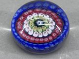 une photo d'une perle de verre ornée d'un motif rouge, blanc et bleu