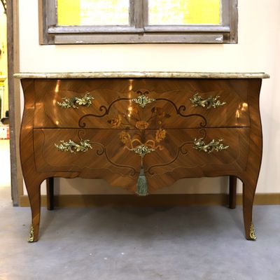 a wooden chest of drawers with a marble top