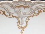 a close up of a white and gold plate with flowers on it