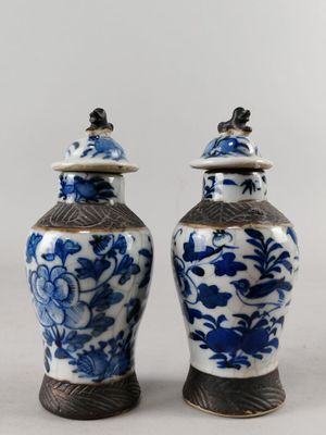 une paire de vases bleus et blancs ornés d'oiseaux sur le dessus