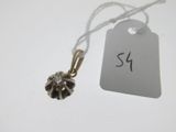 a small black and white flower pendant on a string