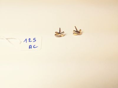 two pairs of earrings that are on a table