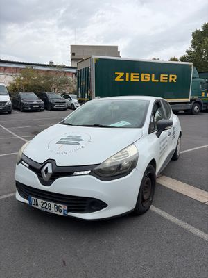 une voiture blanche garée sur un parking à côté d'un camion
