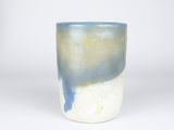 a blue and white cup sitting on a white surface