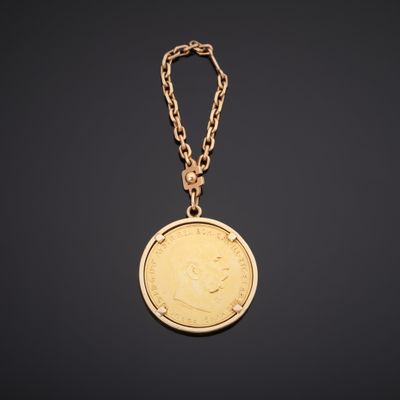 une pièce d'or attachée à une chaîne sur fond noir