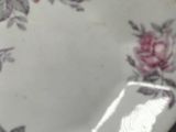 a white plate with pink flowers on it on a table