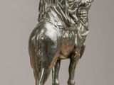 a statue of a man riding on a horse with a sword