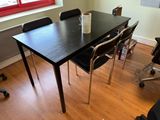 a black table with chairs and a cup on it