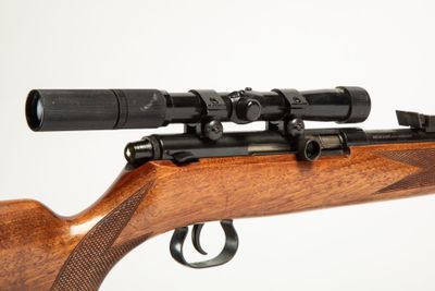 a close up of a rifle with a scope on a white background