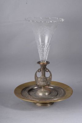 an antique silver plate with a glass vase on top of it