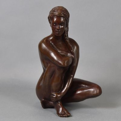bronze statue of a woman kneeling on her knees with her hands on her knees