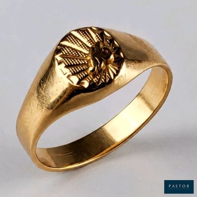 gros plan d'une bague en or sur fond blanc