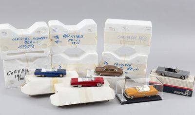 Plusieurs petites voitures sont alignées dans une vitrine posée sur une table