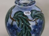 a blue vase with a green leaf design on it