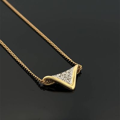 a close up of a gold necklace with diamonds on a black surface