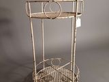 a white metal shelf with a basket on it
