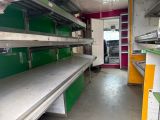 many empty shelves in a store with green and yellow bins