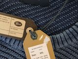a blue sweater with a tag on it and a price tag attached to it